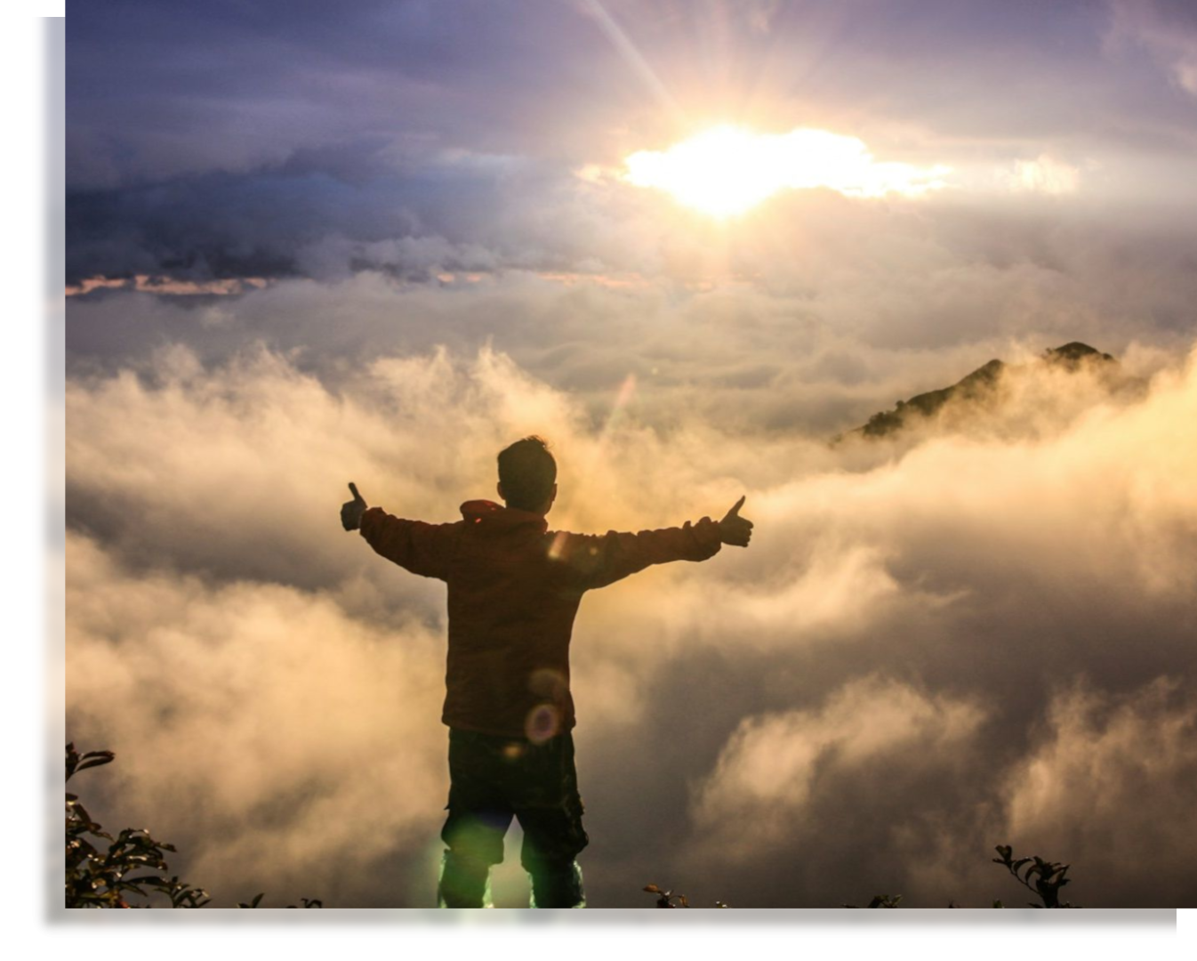 Silhouette of a person with outstretched arms against clouds and a sunrise backdrop.