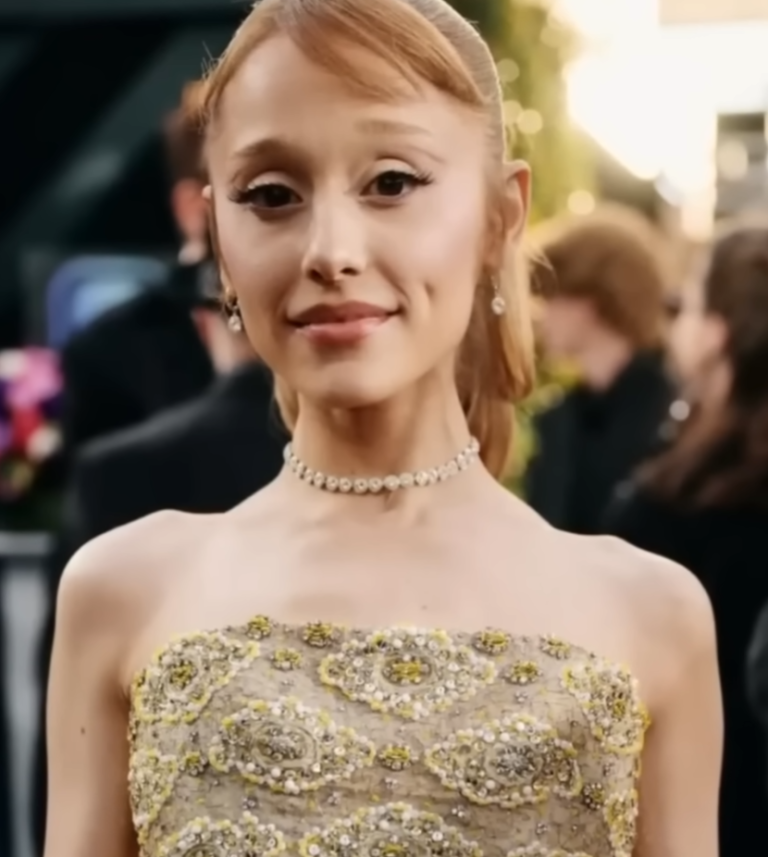 Giovane donna con capelli biondi raccolti, indossa un abito da sera elegante.